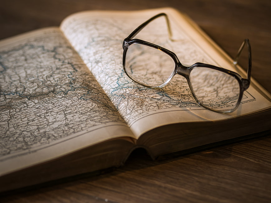 Vintage Glasses on Open Map Atlas Book