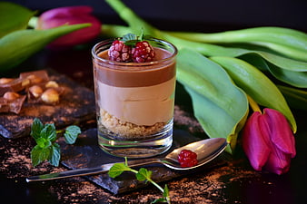 Layered chocolate mousse dessert with raspberries and tulips