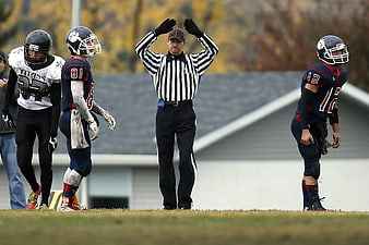 Football Referee Signaling Touchdown Between Players
