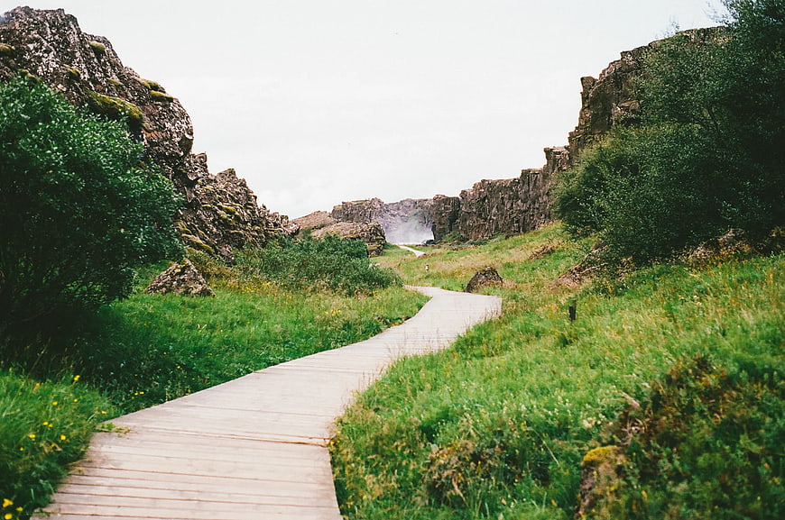 Wooden boardwalk path through rocky canyon to waterfall