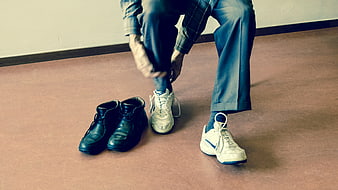 Man Choosing Between Formal Shoes and Sneakers