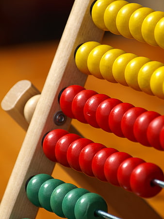 Close-up of colorful wooden abacus beads on orange background