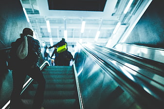 Person Riding Escalator in Modern Building