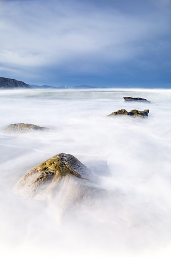 Long Exposure Misty Ocean Waves Over Rocks