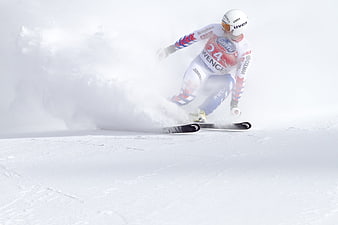 Alpine skier carving turn in powder snow race