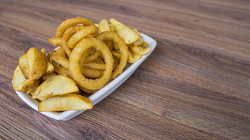 Assorted fried potato snacks on white plate