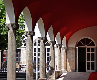 Red Vaulted Ceiling And Stone Columns In Architectural Colonnade