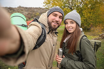 Happy couple hiking selfie in autumn forest