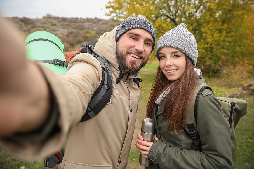 Happy couple hiking selfie in autumn forest