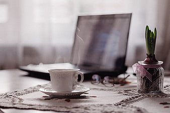 Steaming Tea Cup and Laptop on Lace Tablecloth