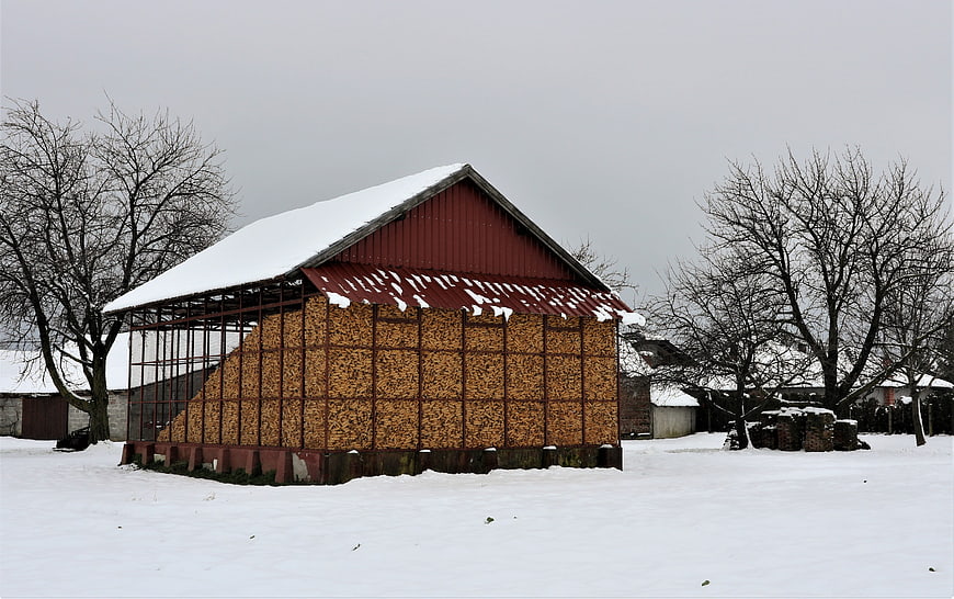 Red Barn Filled with Firewood in Snowy Winter Landscape