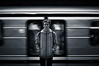 Man standing in front of moving subway train