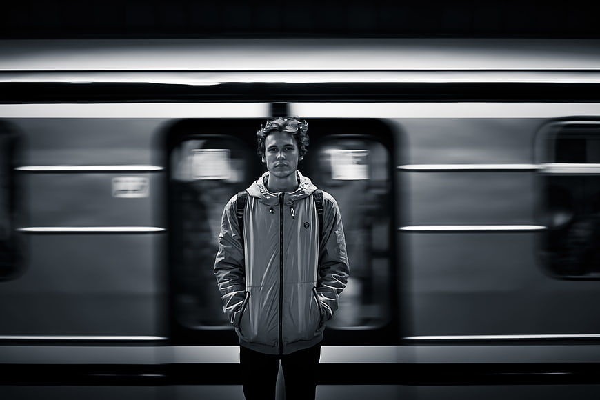 Man standing in front of moving subway train
