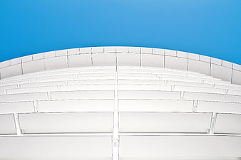White curved architectural structure against blue sky