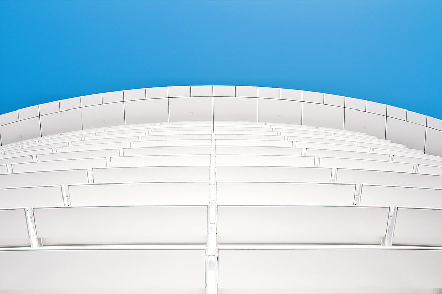 White curved architectural structure against blue sky
