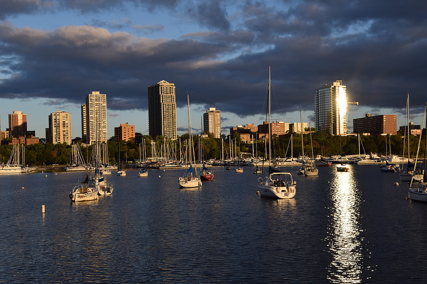 Sunset over city marina with sailboats and skyline