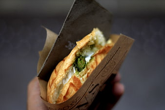 Close-up of Hand Holding Pesto and Cheese Sandwich