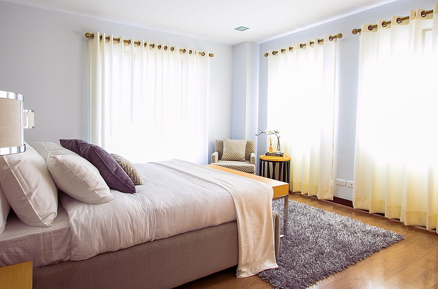 Bright Modern Bedroom with White Bedding and Purple Pillows