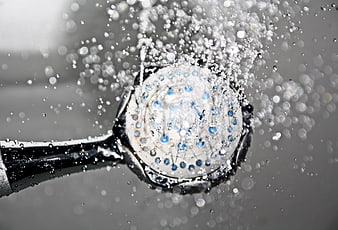 Close-up of shower head spraying water droplets