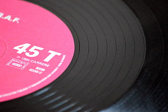 Close-up of a vintage 45 RPM vinyl record with pink label
