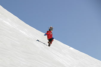 Child Running Down Snowy Hill in Red Jacket