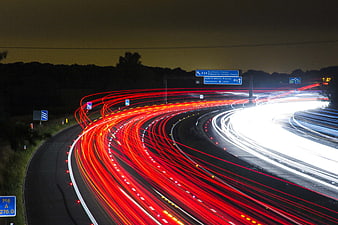 Long exposure light trails on a curving highway at night