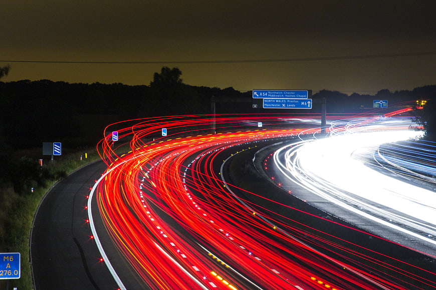 Long exposure light trails on a curving highway at night