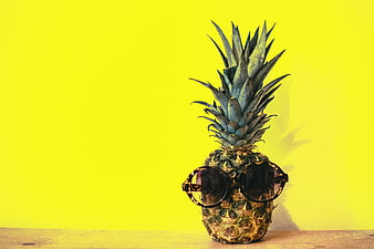 Cool pineapple wearing sunglasses on yellow background
