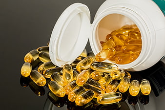 Spilled Golden Fish Oil Capsules from White Bottle