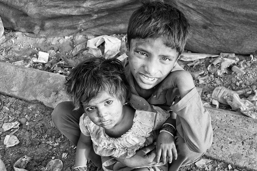 Black and white portrait of two children in poverty