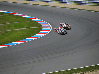 Motorcycle racers leaning into a curve on a race track