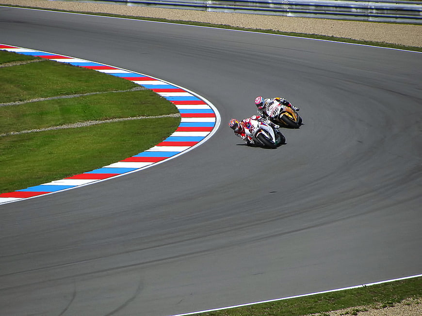 Motorcycle racers leaning into a curve on a race track