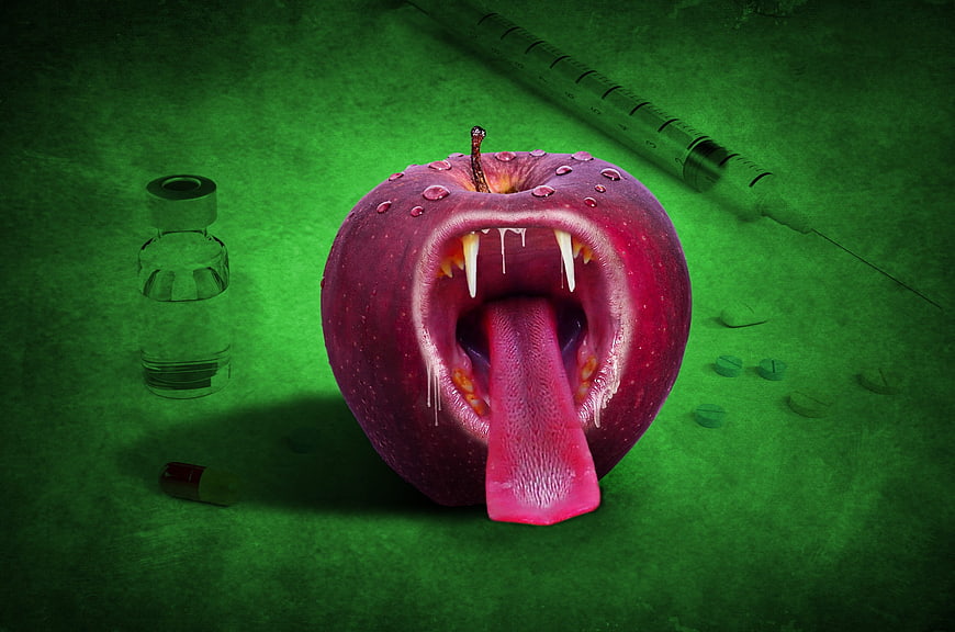 Surreal vampire apple with fangs and medical syringe