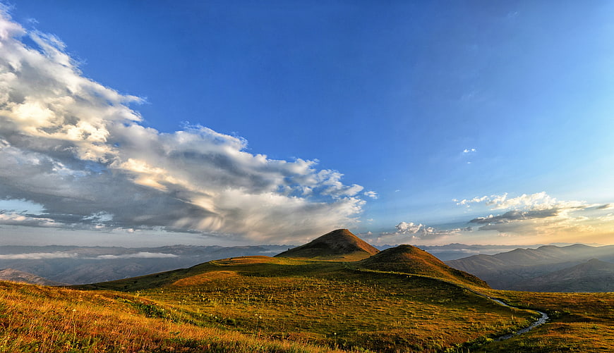 Panoramic Mountain Landscape with Golden Grass and Blue Sky