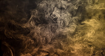 Abstract swirling yellow and brown smoke on dark background