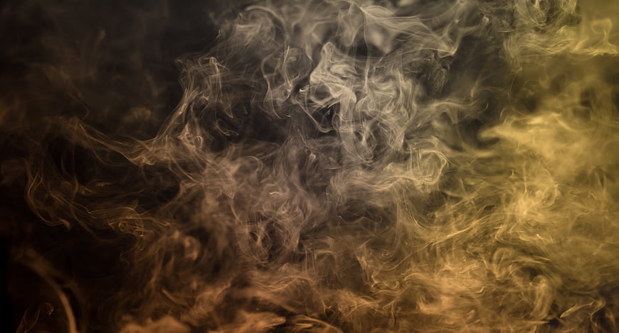 Abstract swirling yellow and brown smoke on dark background