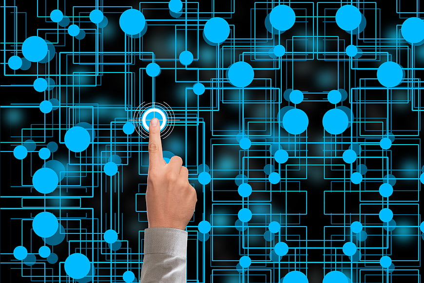 Hand touching glowing blue digital network nodes on black background
