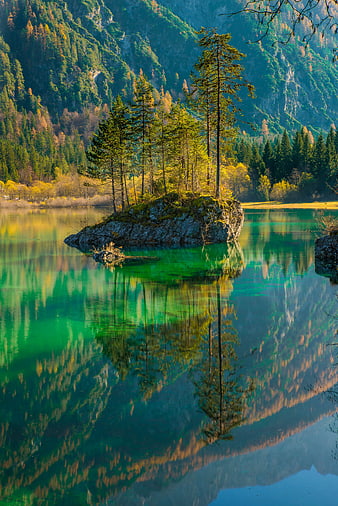 Serene Alpine Lake with Rocky Island and Forest Reflections