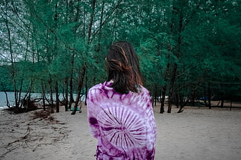 Woman in Purple Tie-Dye Shirt on Sandy Beach
