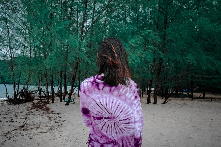 Woman in Purple Tie-Dye Shirt on Sandy Beach