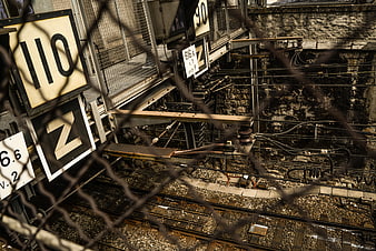 Industrial railway tracks viewed through chain-link fence