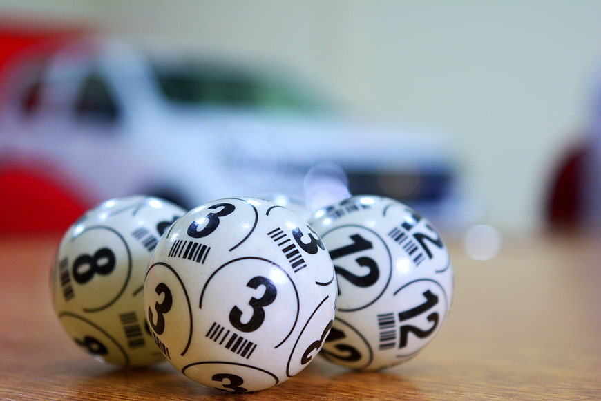 Close-up of white bingo balls with numbers on a wooden table