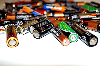 Assorted AA and AAA Batteries Scattered on White Surface