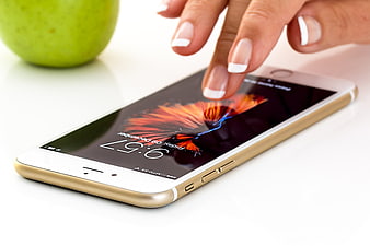 Woman's Hand Touching Smartphone Screen with Green Apple