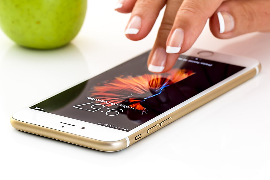 Woman's Hand Touching Smartphone Screen with Green Apple
