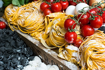 Fresh Italian pasta nests with cherry tomatoes and eggs
