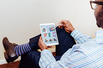 Man analyzing business charts on tablet with striped socks