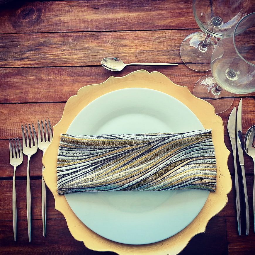 Elegant gold charger plate table setting on rustic wood