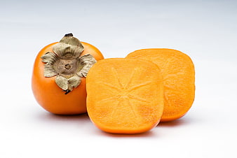 Fresh persimmon fruit whole and sliced on white background