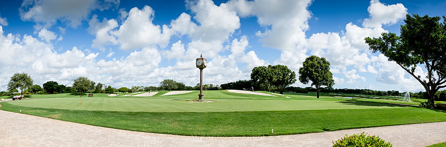 Wide panoramic view of a golf course with a central clock tower